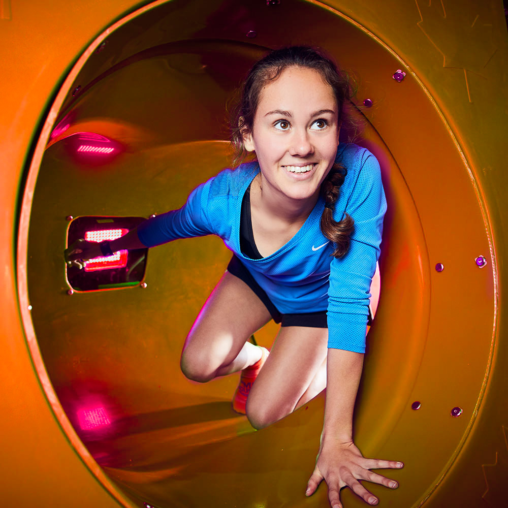 woman crawling through obstacle tube